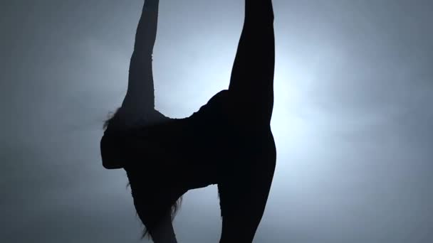 Silhouette junge Mädchen führt die akrobatischen Elemente im Luftring. Zeitlupe. Nahaufnahme. 264