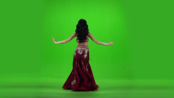 Girl performing belly dance. Green background. Slow motion — Stock Video