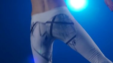 Yakın çekim arka görüş sportif kız mavi projektör karşı atlama. Yavaş çekim