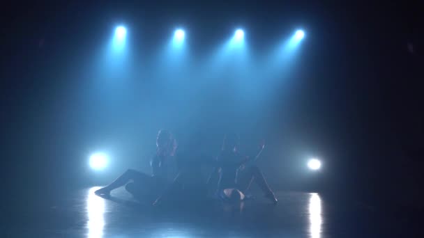 Slow Motion drie mooie vrouwen dansen over spots in Haze — Stockvideo