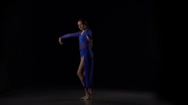 Stüdyonun siyah arka planına karşı dans eden balerin yavaş hareketi