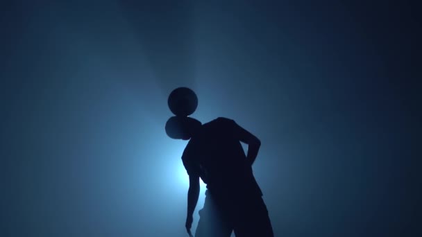 Футболист набивает мяч на плечо в сумерках  . — стоковое видео