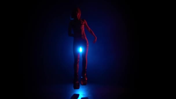 Slow Motion vrouwelijke dansen in Kangoo sprongen schoenen tegen blauwe schijnwerper. — Stockvideo
