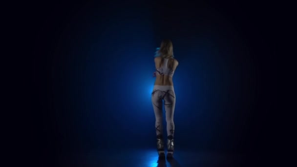 Медленное движение девушки, прыгающей в кангу прыгает обувь против синего прожектора . — стоковое видео