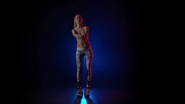 Woman dancing in kangoo jumps shoes against blue spotlight. Slow motion — Stock Video