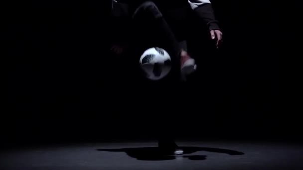 Футбольный фристайл. Медленное движение, профессиональные футболисты набивают мячом ноги в сумерках. Крупный план — стоковое видео