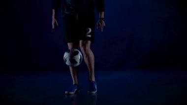 Yakın çekim futbolcular alacakaranlıkta topu doldururken ayaklar. Yavaş çekim