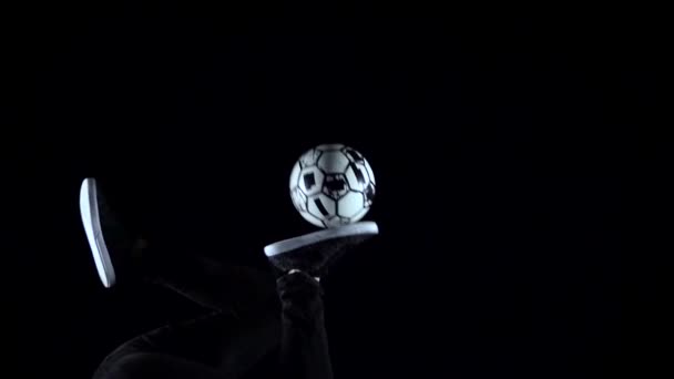 Movimento lento, pés masculinos fazendo truques com bola no crepúsculo. Close-up — Vídeo de Stock