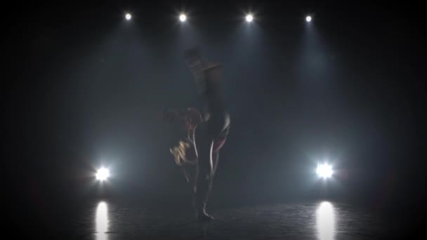 스튜디오에서 스포트라이트에 대한 어둠 속에서 카포에이라를 연습 강한 여성. — 비디오