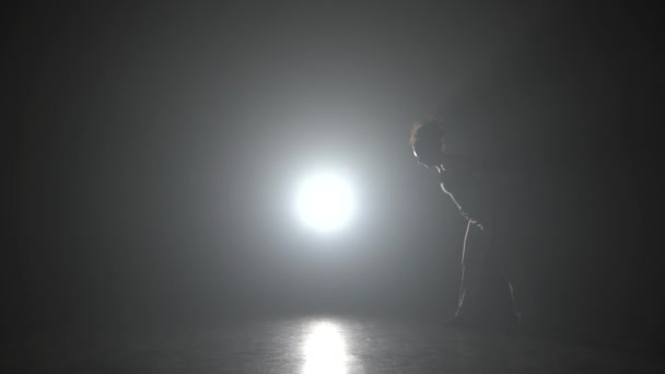 Capoeira en la oscuridad contra proyector de luz en estudio . — Vídeos de Stock