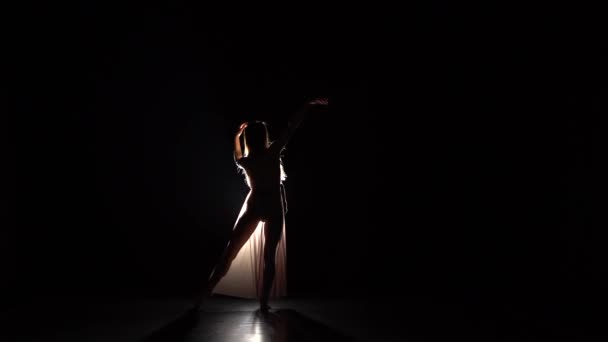 Motion of a graceful girl practicing contemp in dark studio. — Stock Video