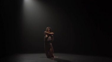 Uzun saç dans ile kız spot altında stüdyoda tefekks