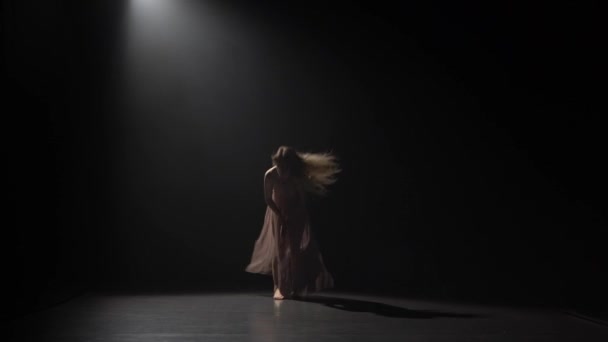 Motion d'une jeune fille dansant en studio sombre . — Video