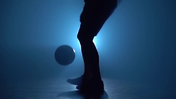 Gros plan des jambes masculines en peluche balle contre projecteur bleu. Mouvement lent — Video