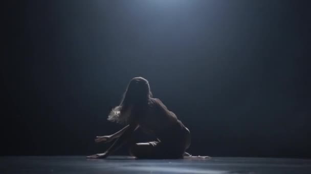Close-up beweging van de vrouw die overweegt in donkere Studio — Stockvideo