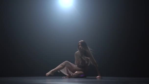 Леди танцует современно в студии в лучах прожектора . — стоковое видео