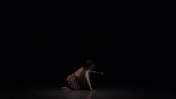 Девушка танцует созерцание в сумерках студии. Медленное движение — стоковое видео