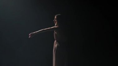 Kadın stüdyoda siyah arka plan karşı tefekks performans. Yavaş çekim