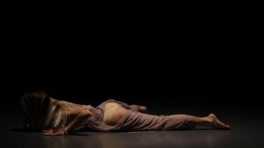 Şehvetli bayan spot karanlık stüdyoda tefekkme performans. Yavaş çekim