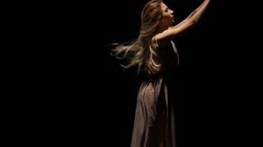 Siyah arka plana karşı spot ışıklarında dans eden kız. Yavaş çekim