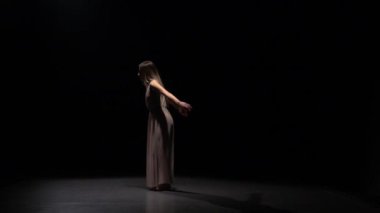 Spot ışıkları kiriş karanlık stüdyoda kadınsı kız dans.