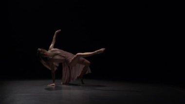 Dansçı spot siyah arka plan karşı dans unsurları performans.