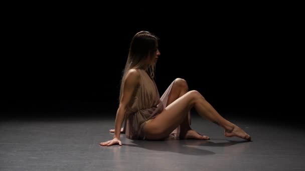 Όμορφη γυναίκα που χορεύει σύγχρονα σε σκοτεινό στούντιο στο προσκήνιο. Αργή κίνηση — Αρχείο Βίντεο