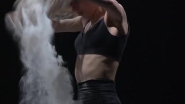 Yakın çekim virtüöz dansçı havaya toz parçacıkları atıyor. Yavaş çekim