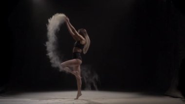 Kadın stüdyoda havaya toz parçacıkları atıyor. Yavaş çekim