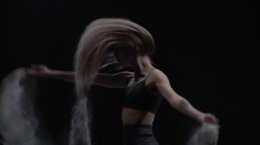 Yakın çekim yavaş çekim, havada toz parçacıkları atan talanted dansçı.