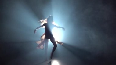 Spot ışığına karşı karanlık stüdyoda kadın dans tefekks. Yavaş çekim