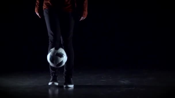 Estilo libre de fútbol. Primer plano jugadores de fútbol piernas haciendo trucos con pelota en sudio. Movimiento lento — Vídeo de stock