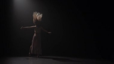 Stüdyoda uzun saçlı dans eden şehvetli bir kadın. Yavaş çekim