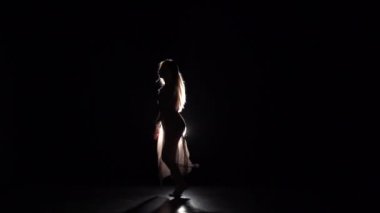 Zarif kız karanlık stüdyoda çağdaş pratik. Yavaş çekim