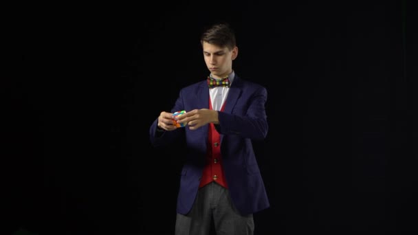 Ukraine, Dnipro 20 Feb 2019 : Un homme brune en costume résout Rubiks Cube dans l'obscurité . — Video