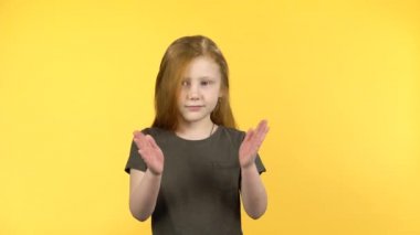 Pretty kız sarı arka plan üzerinde mutlu alkışlar