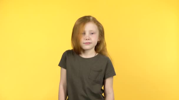 Bonito ruiva bebê dança encolhendo sobre amarelo fundo — Vídeo de Stock