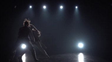 Yavaş çekim kadın stüdyoda spot karşı karanlıkta capoeira pratik.