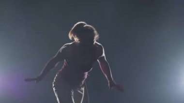 Spotligh'e karşı capoeira uygulayan yakın çekim kadın. Yavaş çekim.