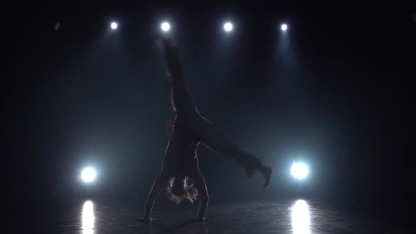 Zeitlupe Frau übt Capoeira in der Dunkelheit im Studio. — Stockvideo
