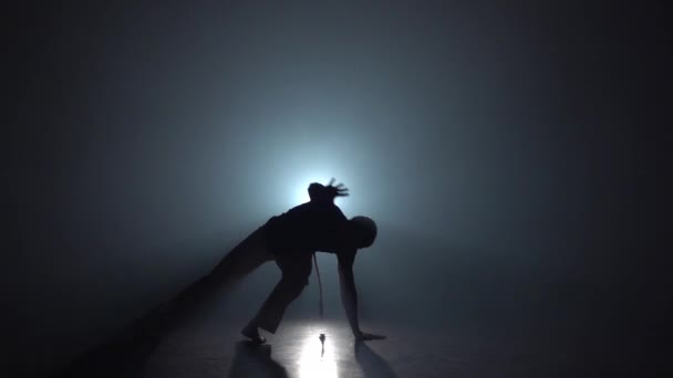 Capoeira. Silueta de macho en oscuridad contra proyector de luz. Movimiento lento . — Vídeo de stock