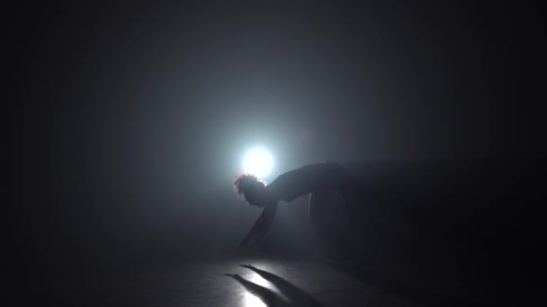 Capoeira. Silueta de mujer en oscuridad contra proyector de luz. Movimiento lento . — Vídeos de Stock