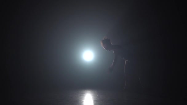 Capoeira. Mulher no estúdio escuro contra holofotes de luz. Movimento lento . — Vídeo de Stock