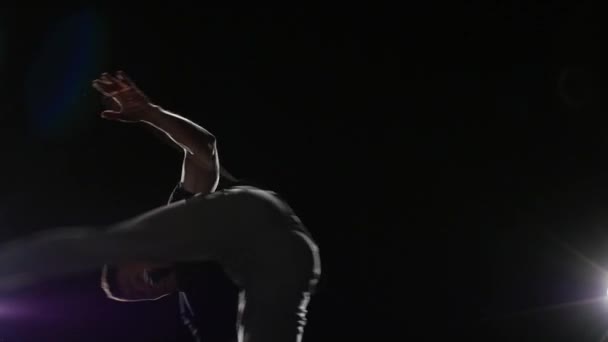 Dansare praktiserande Capoeira i mörker mot Spotlight. Närbild slow motion. — Stockvideo