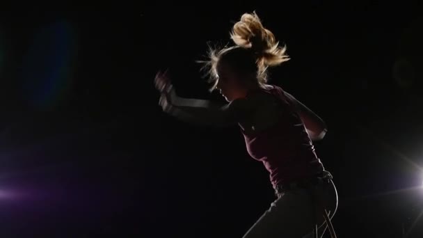 Blízkánská tanečnice trénuje capoiru v temnotě proti reflektoru. Zpomaleně. — Stock video