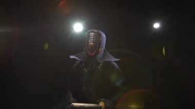 Kendo gurusu geleneksel bir zırh ve kask yerde oturuyor. Dolly atış