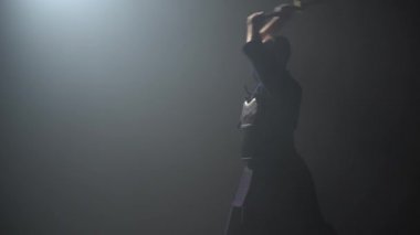 Kendo eğitmen karanlık stüdyoda Katana shinai ile dövüş sanatı pratik.