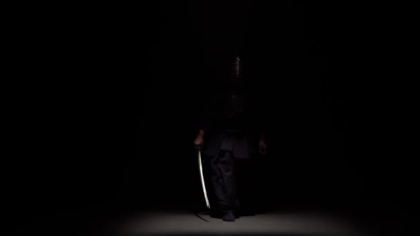 Kendo Fighter Performing Martial Art met Katana sword in dark studio onder Spotlight. — Stockvideo