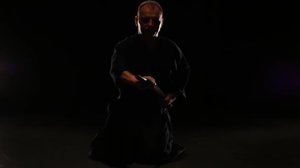Волевой боец Кендо склоняется перед своим мощным мечом Катаны, замедленным движением — стоковое видео