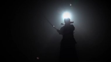 Siluet kendo eğitmen Katana kılıç ile dövüş sanatı pratik ediyor. Yavaş çekim.